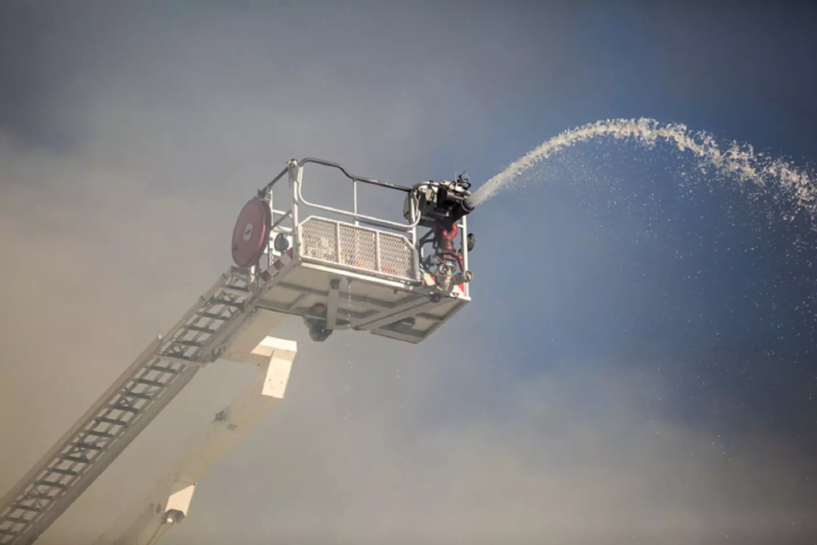 strażak gaszący pożar na podnośniku